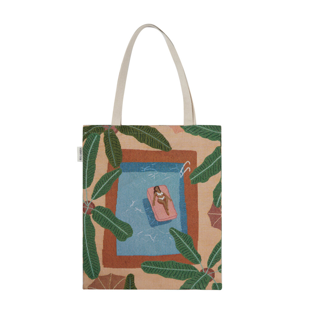 Rugopera Oasis Prelude luxury tapestry tote bag, featuring Kai Owens’ tropical poolside artwork with crystalline water and lush foliage.